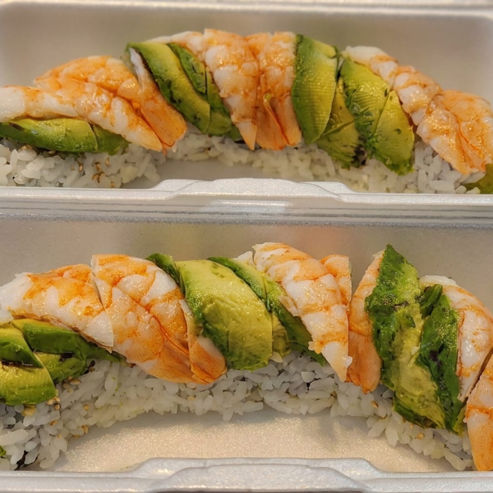 Two takeout containers hold shrimp and avocado sushi rolls over seasoned white rice.